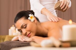 woman massage with candles and flowers